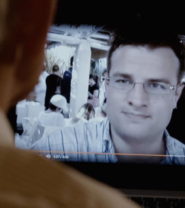 "Abgezockt! Der Anlagebetrüger Felix Vossen": Eine Person, die nur von hinten im Anschnitt zu sehen ist, schaut auf einen Computerbildschirm, auf dem Felix Vossen abgebildet ist.