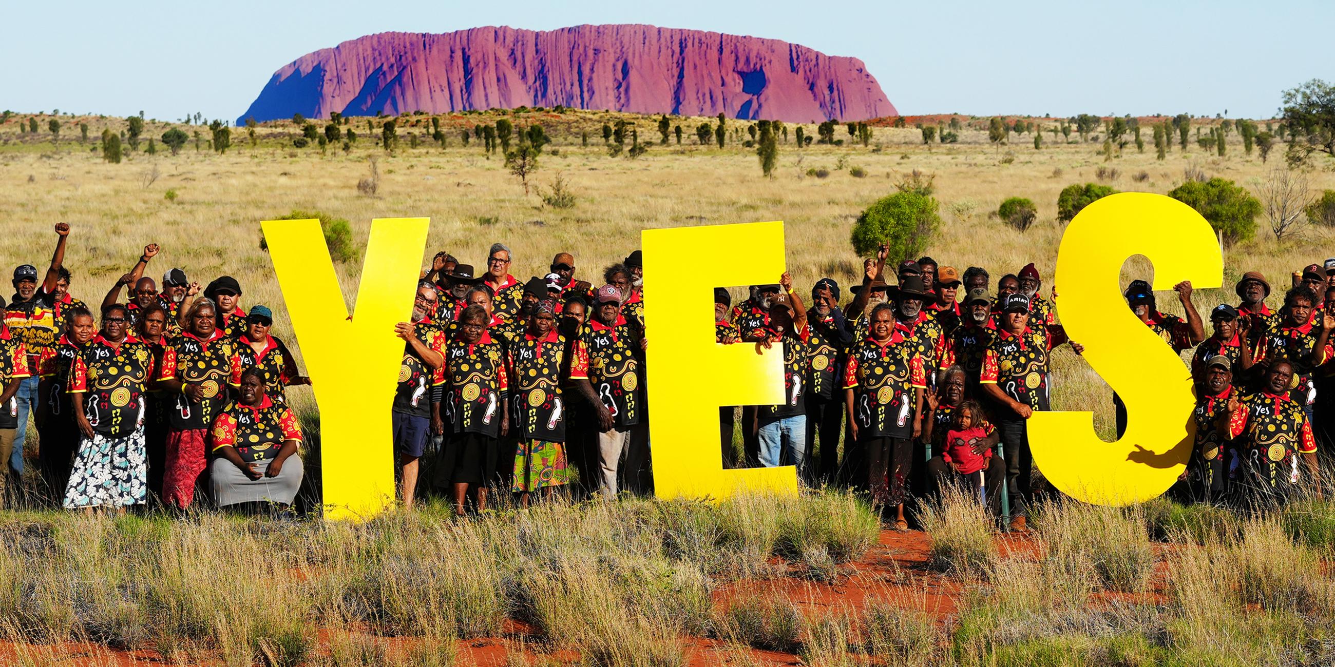 Ein von Delegierten des Central Land Council zur Verfügung gestelltes Foto zeigt Delegierte des Councils nahe Uluru die Buchstaben Yes (Ja) halten, aufgenommen am 03.10.2023