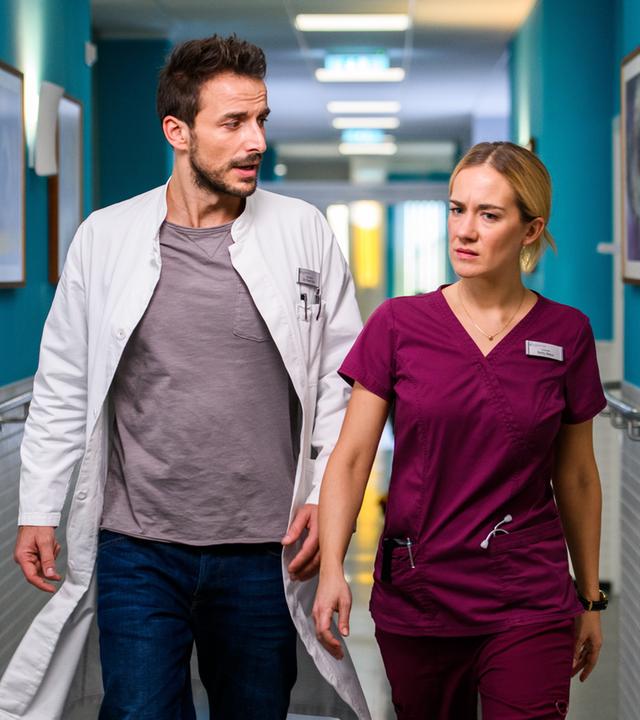 "Bettys Diagnose - Abschied": Betty Weiss (Annina Hellenthal) und Dr. Frank Stern (Max Alberti) eilen mit ernsten Mienen den Klinikflur entlang.
