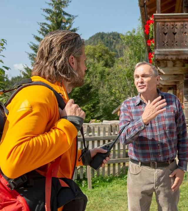 Vor dem Haus stehen Bruno Steyer (Franz Froschauer) und Mona (Nina Steils) dem Bergretter Markus Kofler (Sebastian Ströbel) gegenüber. 