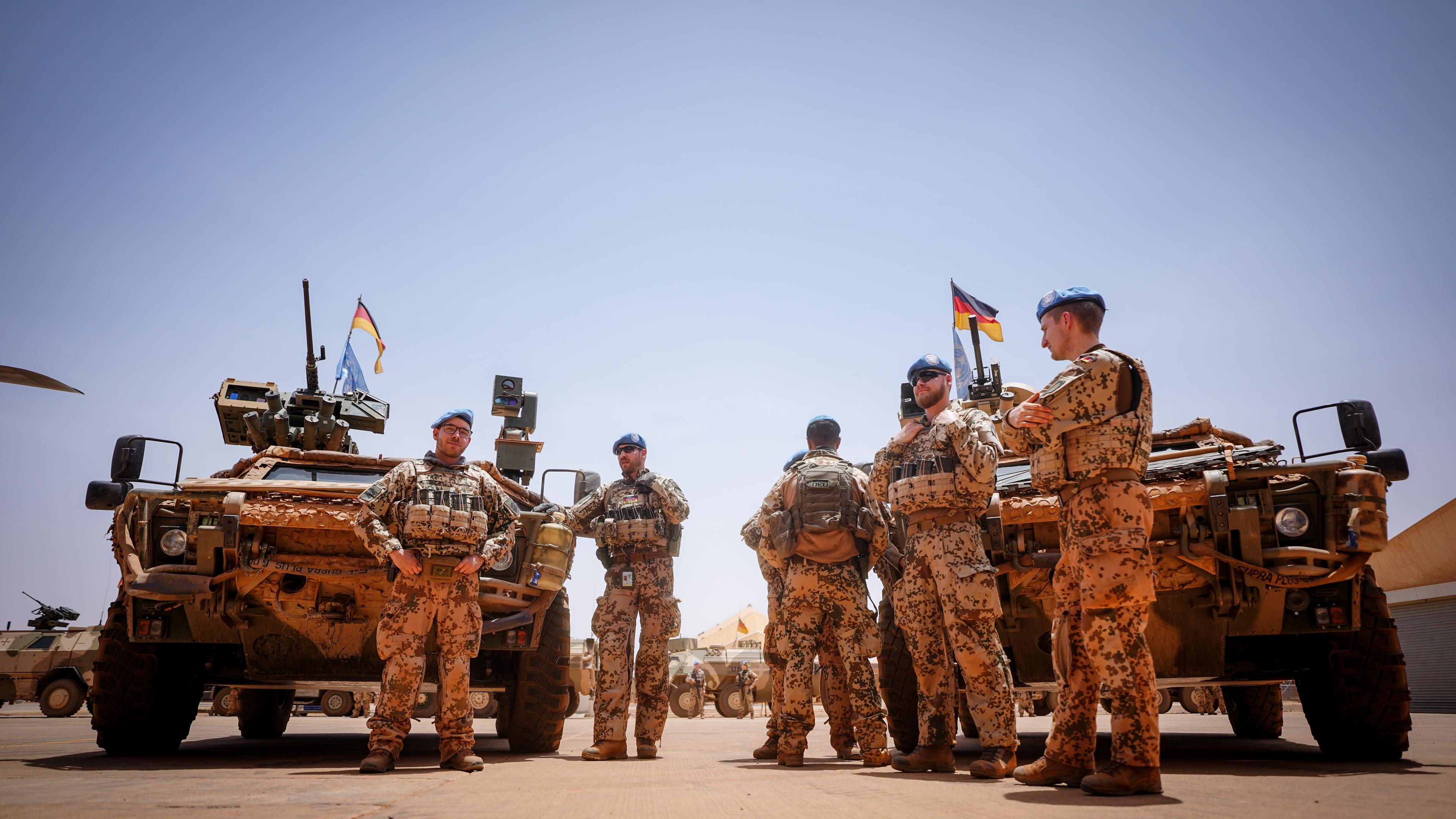 Bundeswehrsoldaten stehen in Gao in Mali im Feldlager Camp Castor an ihren Fahrzeugen