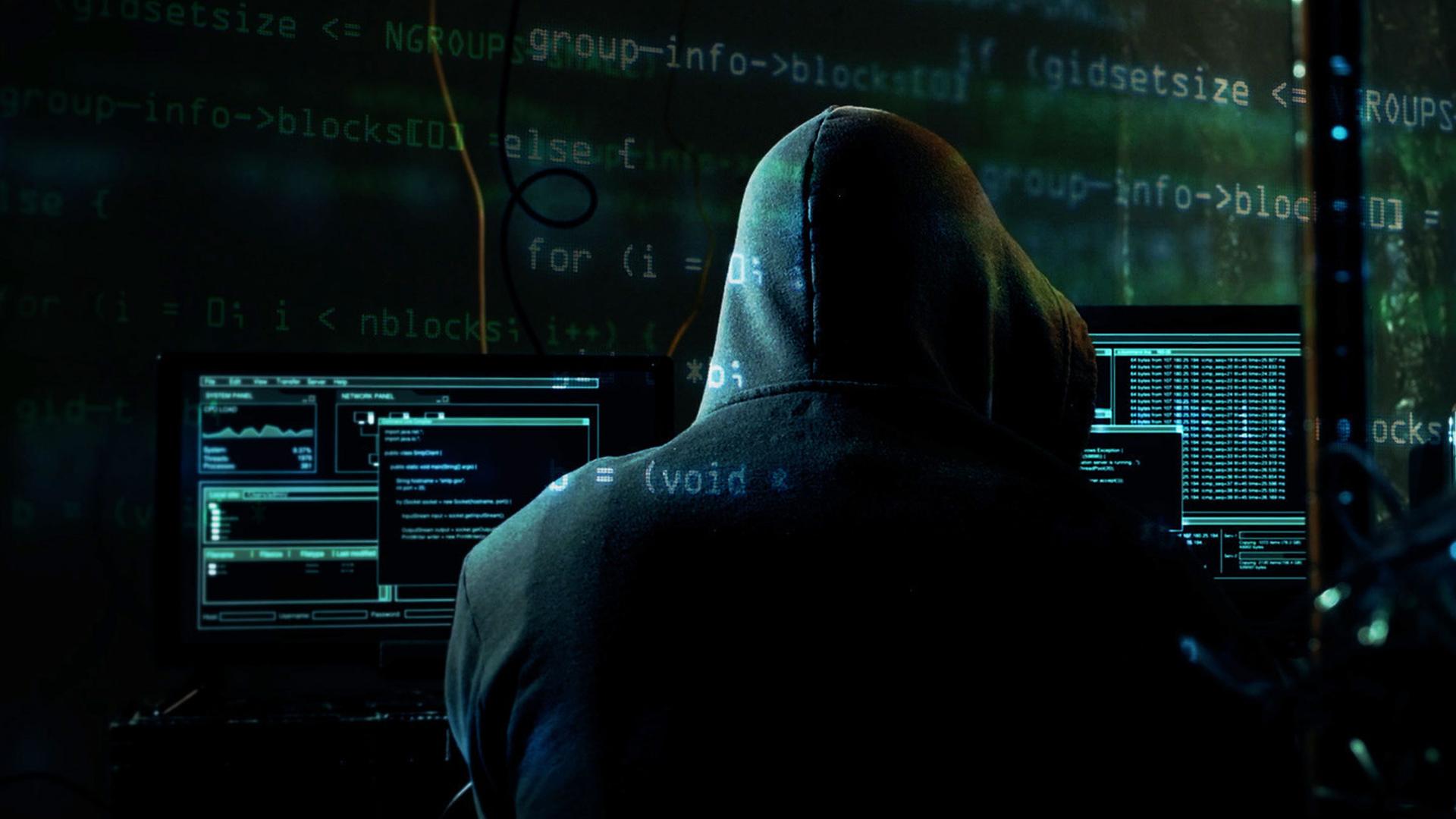 "Achtung, Geldfallen! - Die Tricks der Finanzabzocker": In einem abgedunkelten Raum sitzt ein Mensch vor mehreren Monitoren. Er trägt einen dunklen Kapuzenpulli und ist nur von hinten zu sehen.