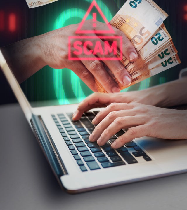 Laptop mit Achtung Scam Zeichen und Hand, die Geldscheine hält