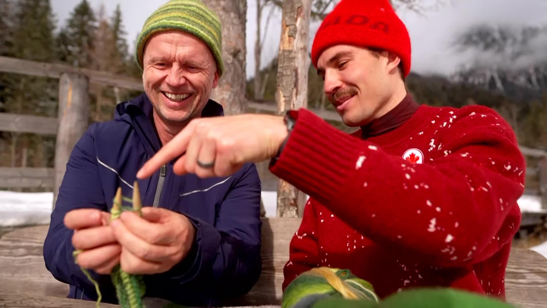 Der kanadische Biathlet Adam Runnalls strickt zusammen mit dem ZDF-Reporter Alex Ruda in Antholz