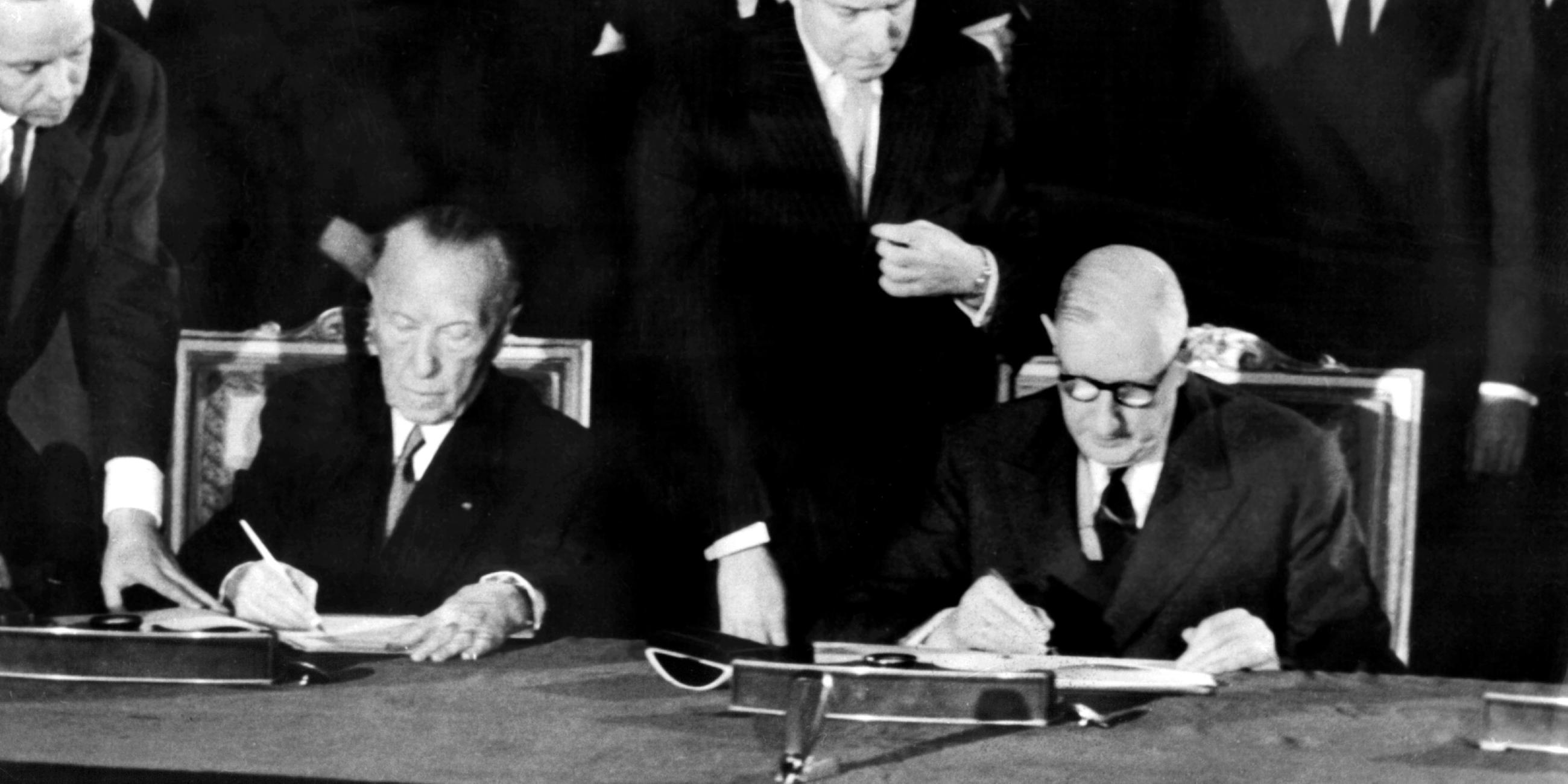 Schwarzweiß-Foto: Adenauer und De Gaulle unterschreiben Élysée-Vertrag