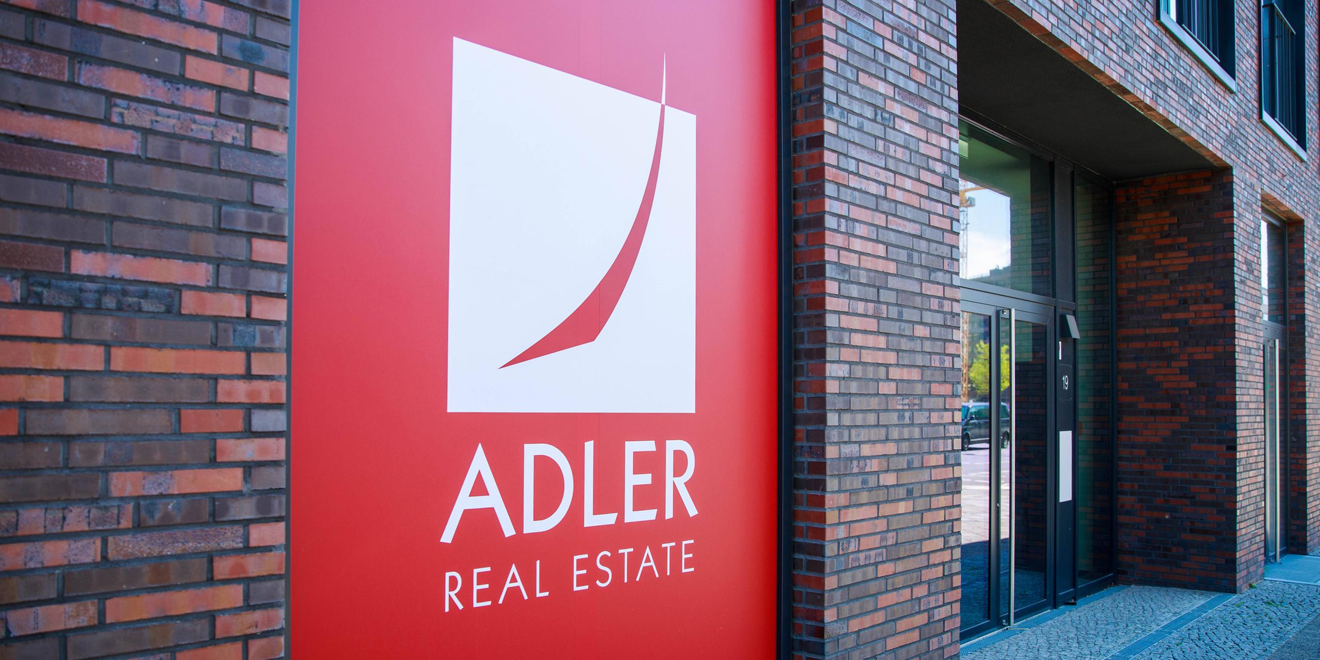 "Adler Real Estate"-Logo als Aukleber an das Front eines Neubaus.