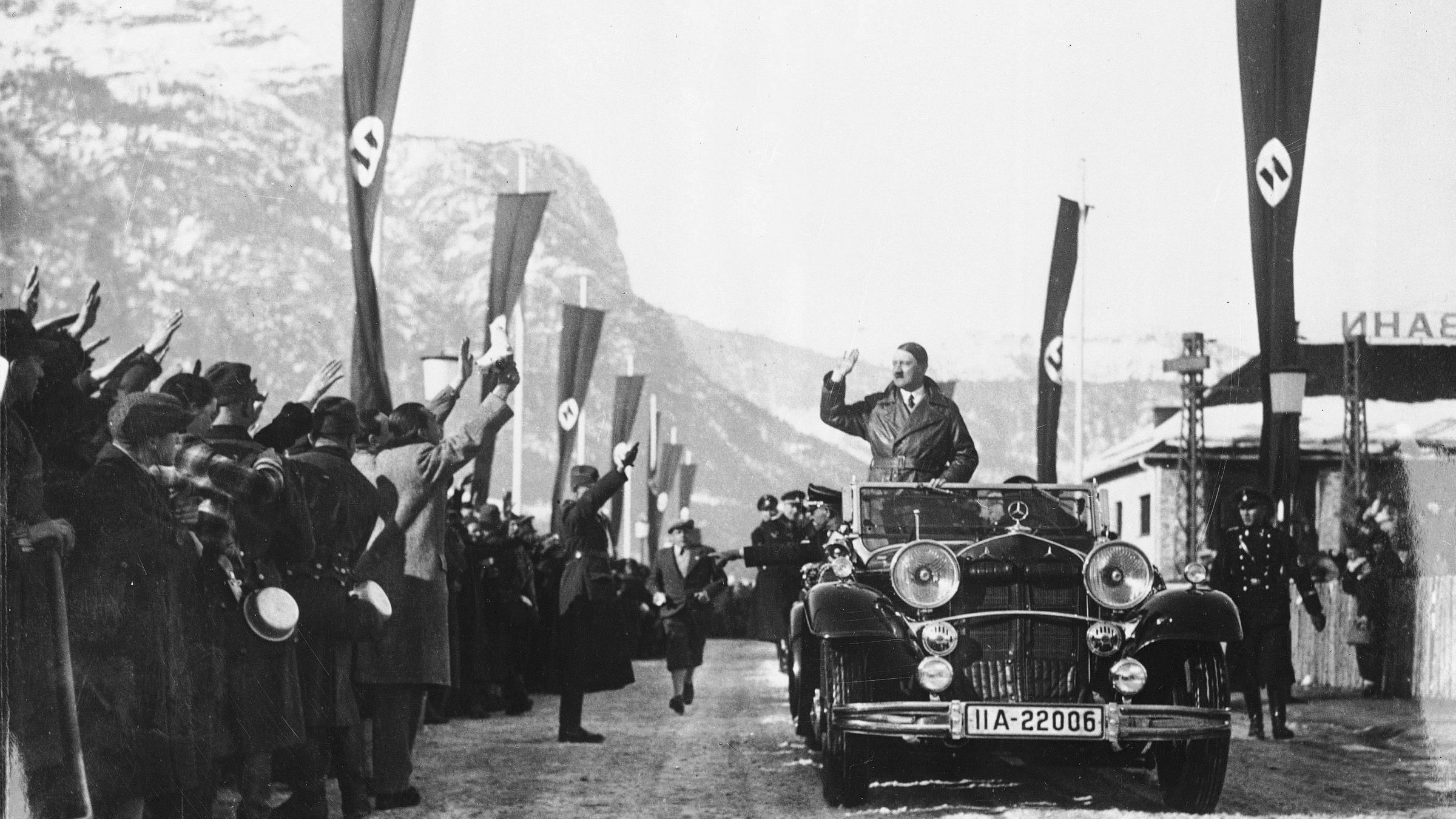 "Die Jahreschronik des Dritten Reichs (2) 1936 bis 1939: Der Weg zum Krieg": Adolf Hitler bei den Olympischen Winterspielen 1936 in Garmisch-Partenkirchen winkt stehend in einem offenen Auto.
