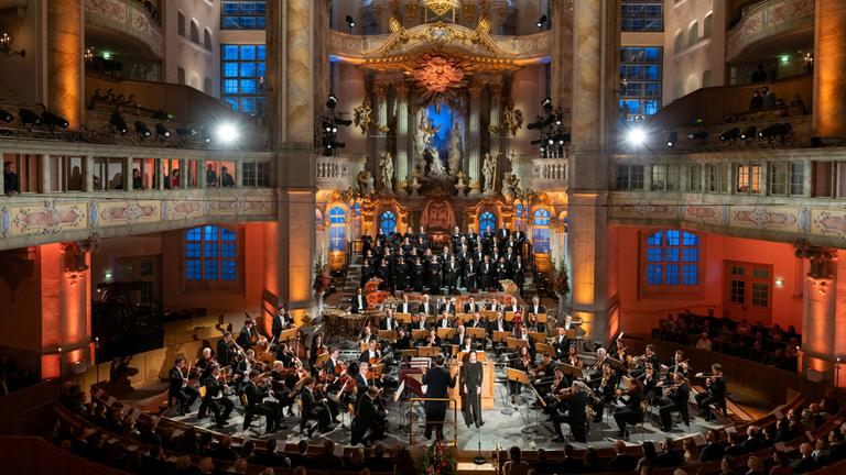 Blick in den festlich beleuchteten Altarraum der Dresdner Frauenkirche mit den Musikern der Staatskapelle Dresden, dem Dirigenten Christian Thielemann und der Sopranistin Hanna-Elisabeth Müller.