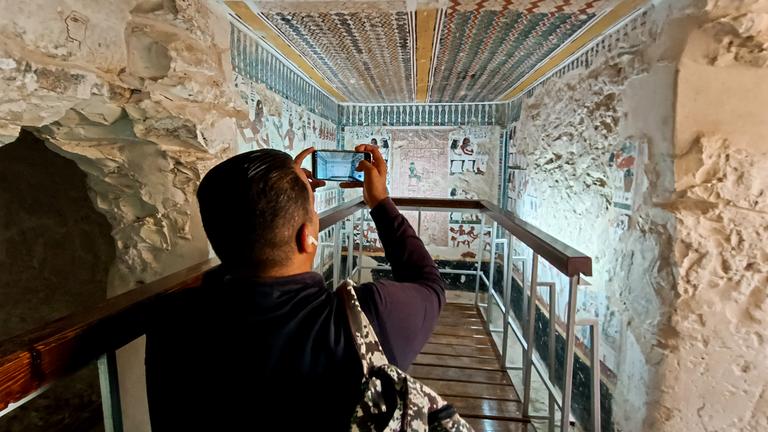  Ein Besucher fotografiert im Inneren des kürzlich restaurierten antiken Grabes des Amenhotep in der Nekropole von El-Khokha am Westufer des Nils in Luxor, Ägypten.
