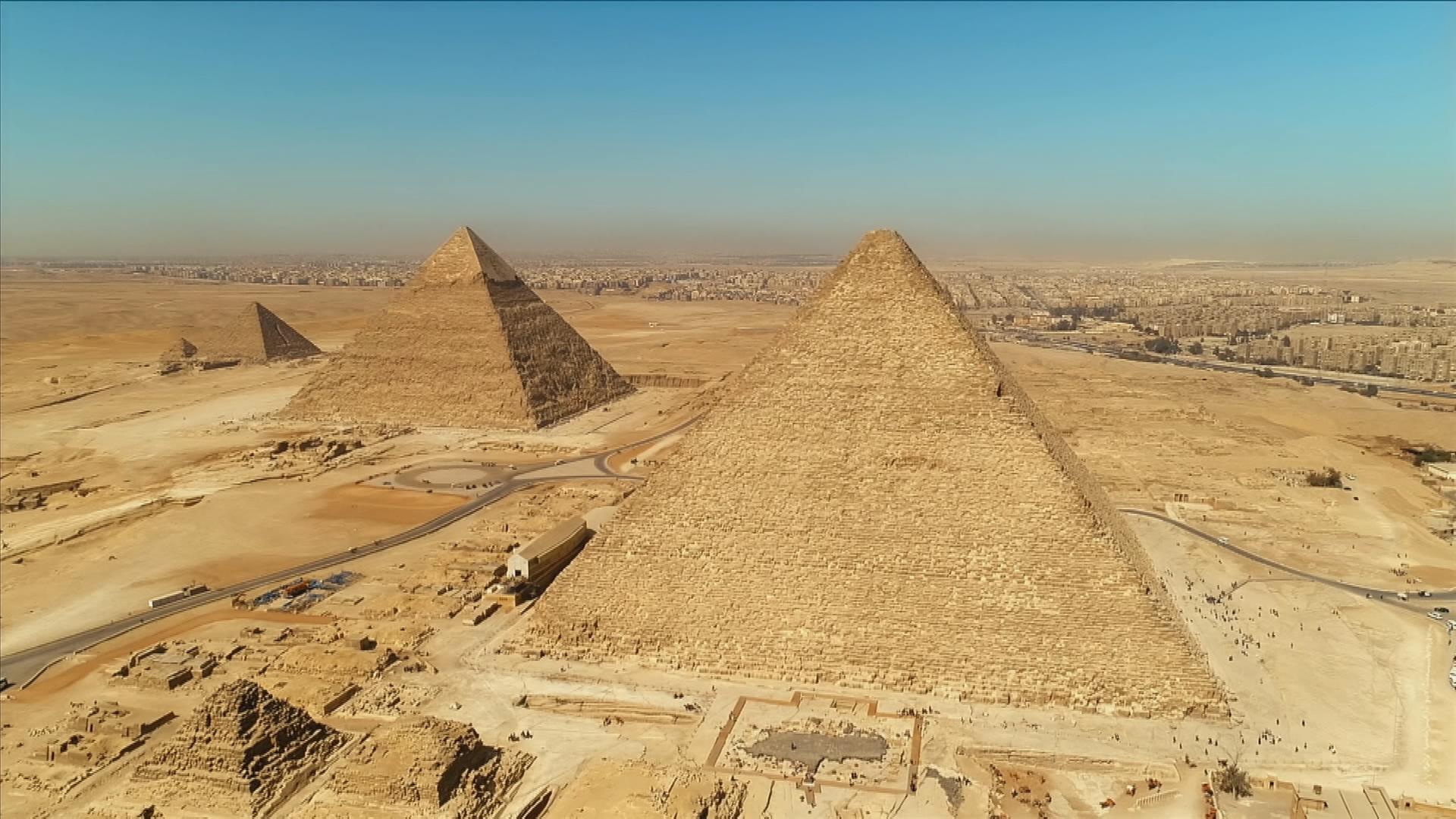 Luftbild der drei Großen Pyramiden von Gizeh. Im Vordergrund liegt die Cheops-Pyramide links dahinter die Chefren-Pyramide. Im Hintergrund liegt die Pyramide des Mykerinos, die kleinste der drei Pyramiden.