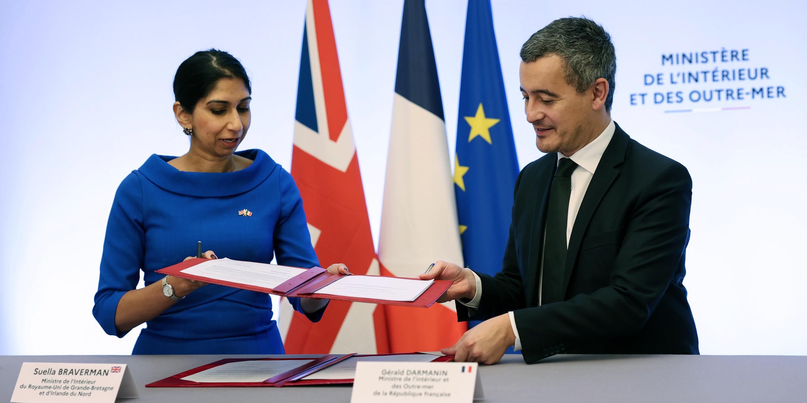 Der französische Innenminister Gerald Darmanin und die britische Innenministerin Suella Braverman unterzeichnen eine gemeinsame Erklärung zum Migrationsabkommen. 