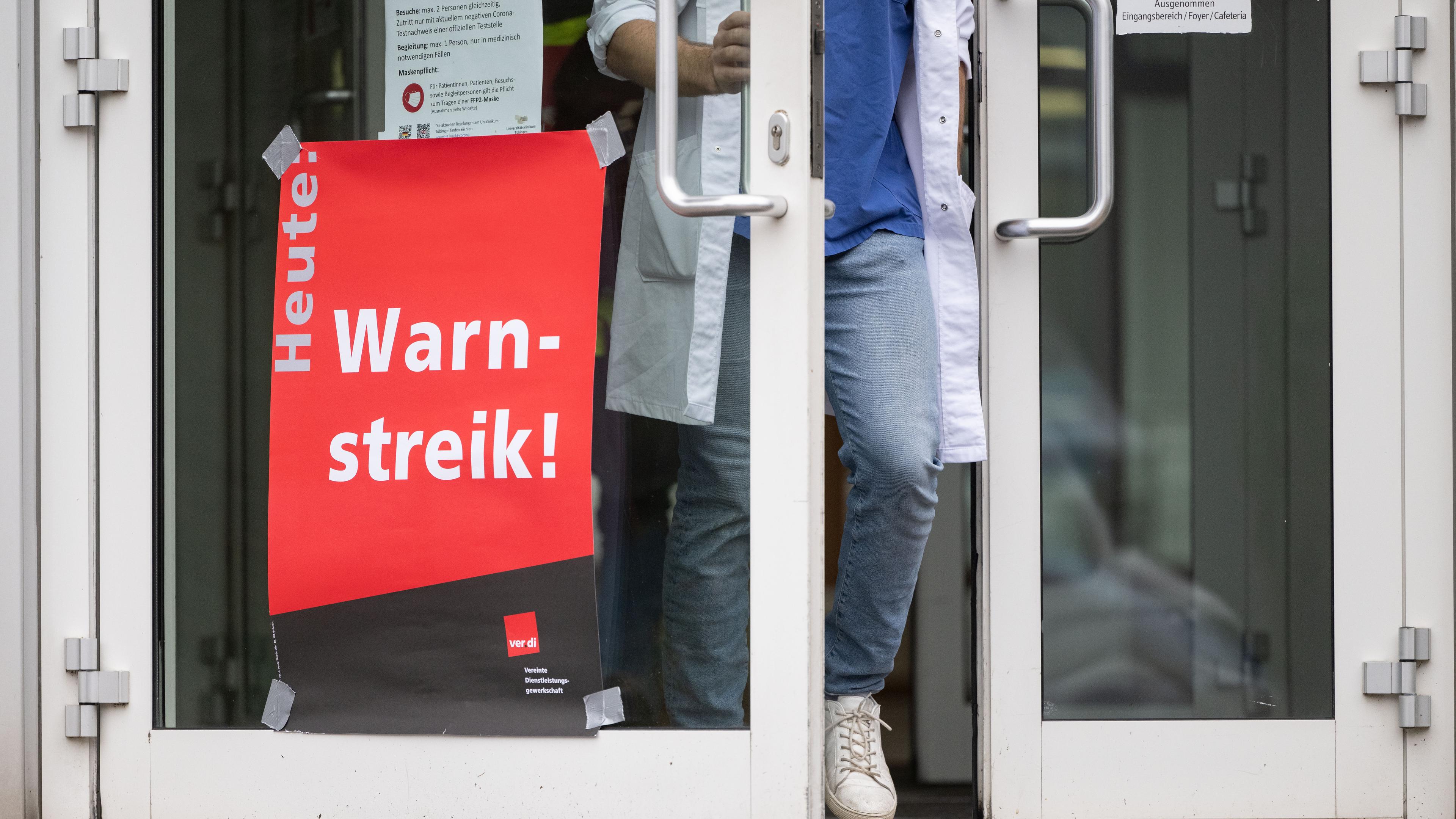 Baden-Württemberg, Tübingen: Ein Plakat mit der Aufschrift «Heute Warnstreik» hängt am Eingang eines Gebäudes des Universitätsklinikum Tübingen.