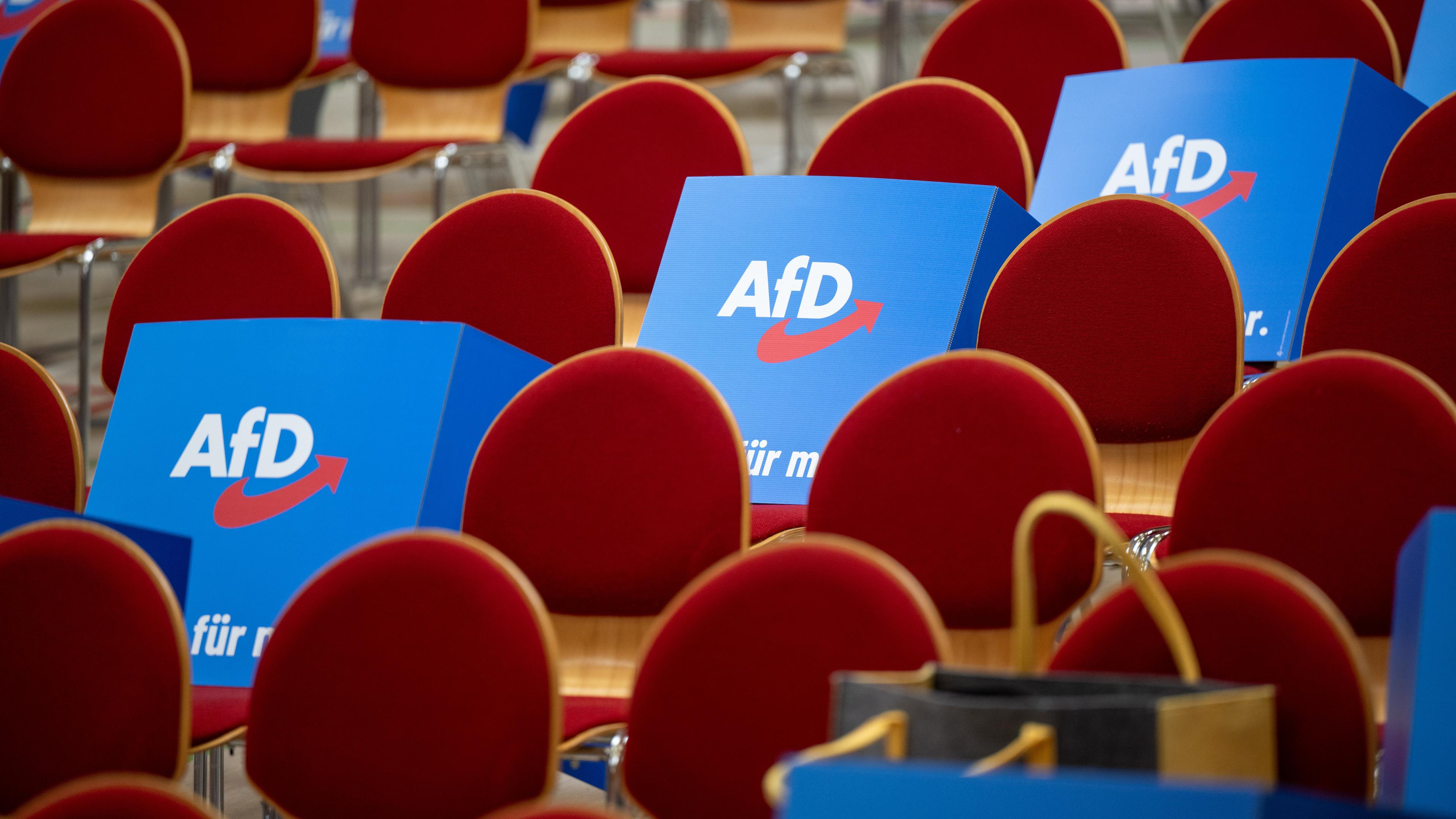 Pappaufsteller mit dem Logo der AfD liegen vor Beginn des Landesparteitags der AfD Brandenburg auf  Stühlen.