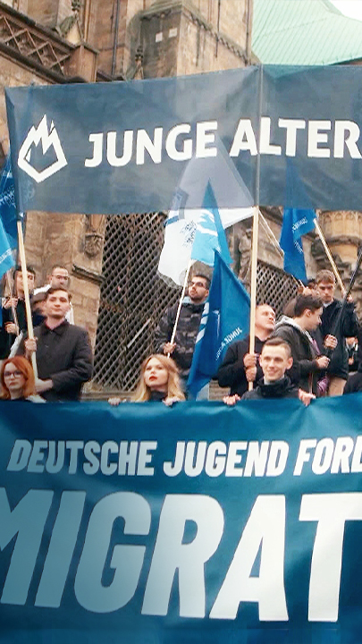 Demo "Junge Alternative", Teilnehmer mit Banner: "Deutsche Jugend fordert Remigration!"
