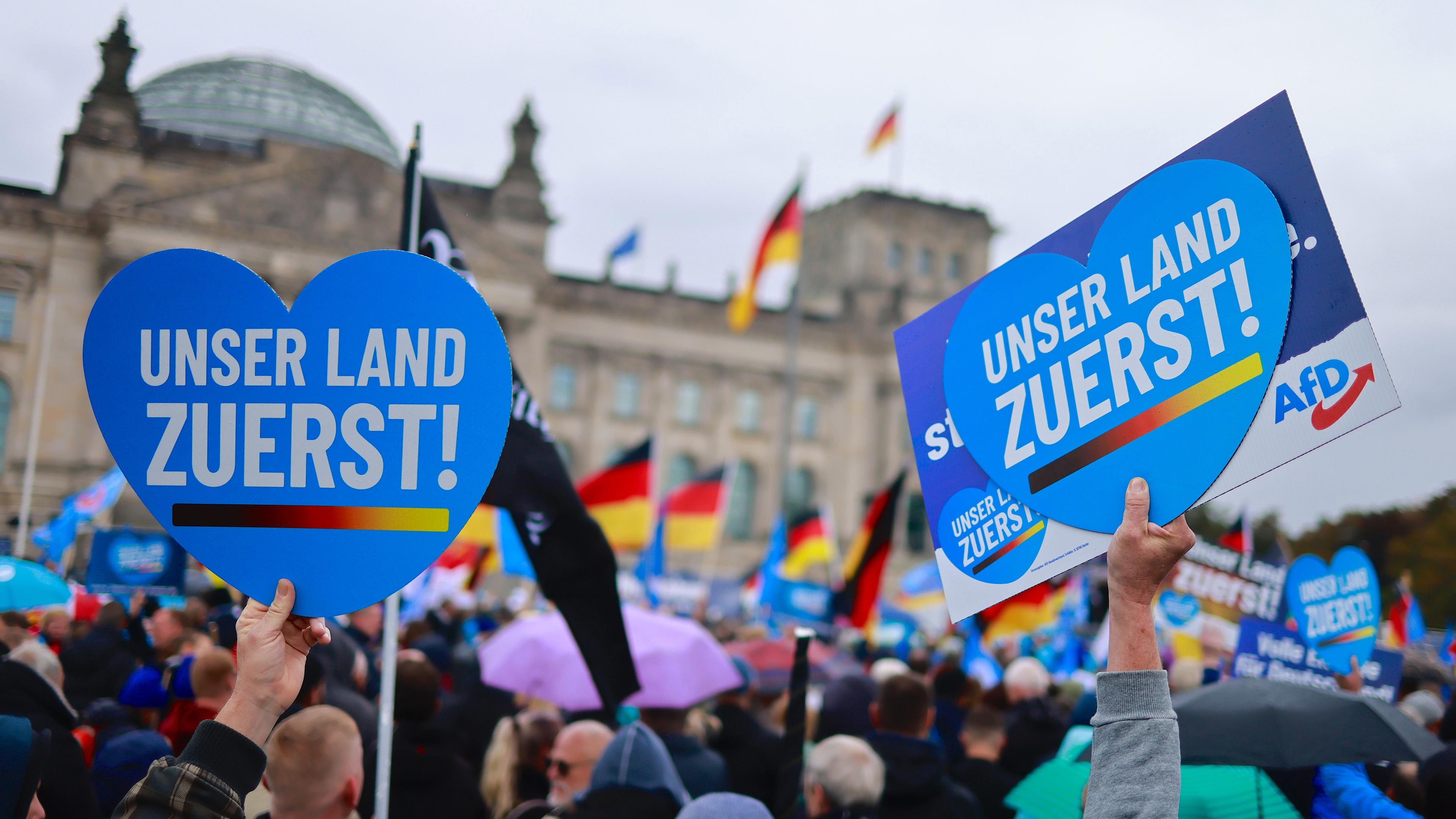 Archiv: Demonstranten halten Plakat vor Bundestag mit Schrift "Unser Land Zuerst!"
