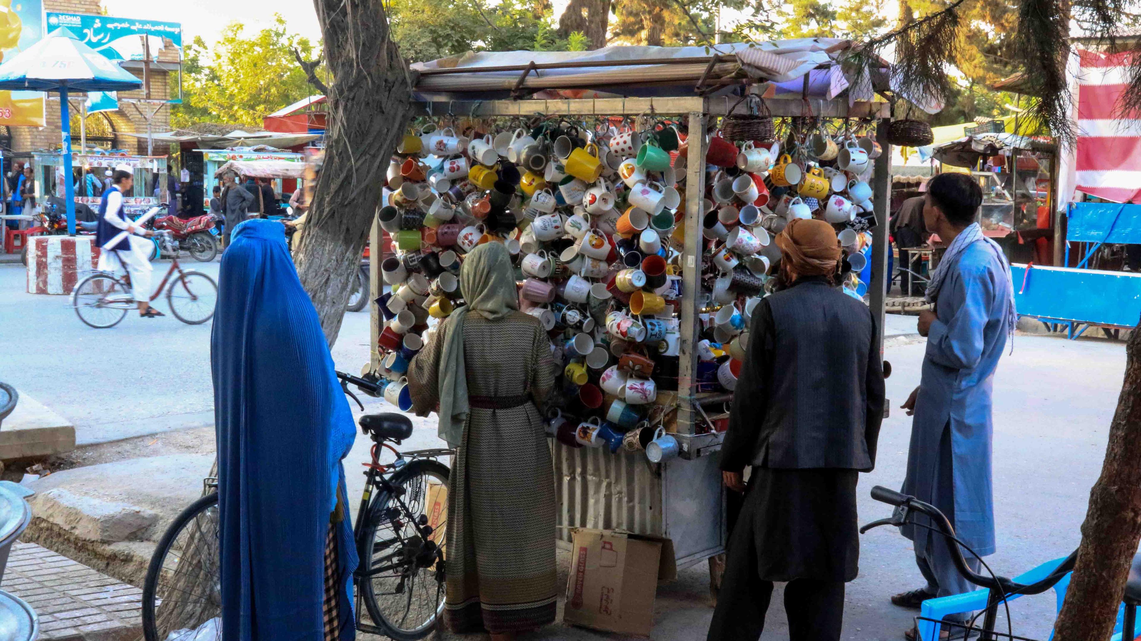 Straßenladen in Kabul mit Haushaltswaren, an dem mehrere Menschen anstehen.