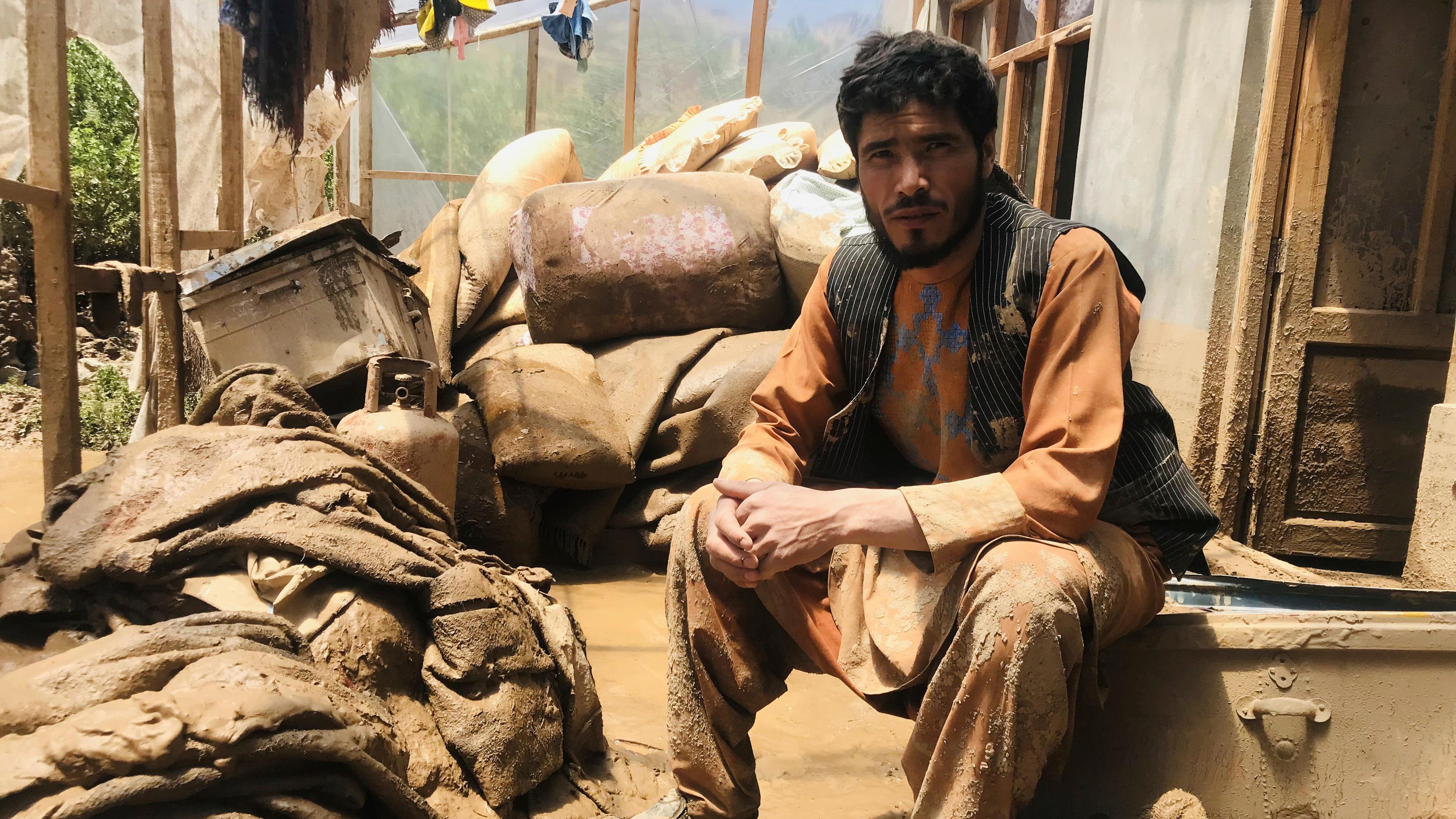 Ein afghanischer Mann sitzt in seinem von der Überschwemmung beschädigten Haus