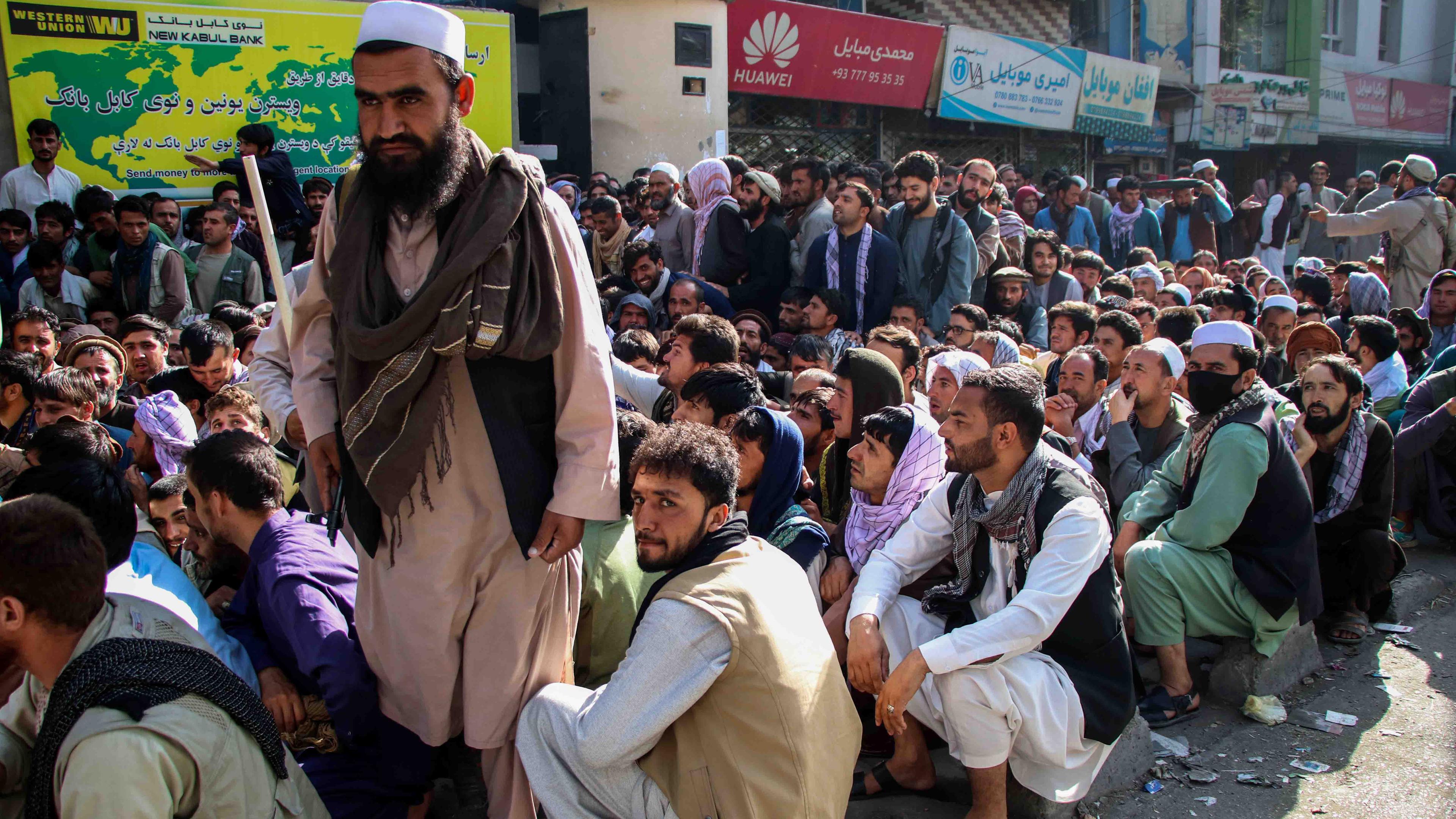 Männer warten dicht gedrängt vor einer Bank in Kabul