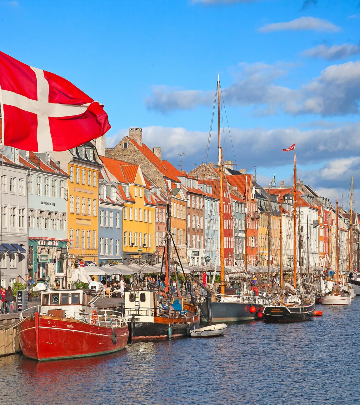 Nyhavn in Kopenhagen an einem sonnigen Tag es ist die dänische Flagge zu sehen. 