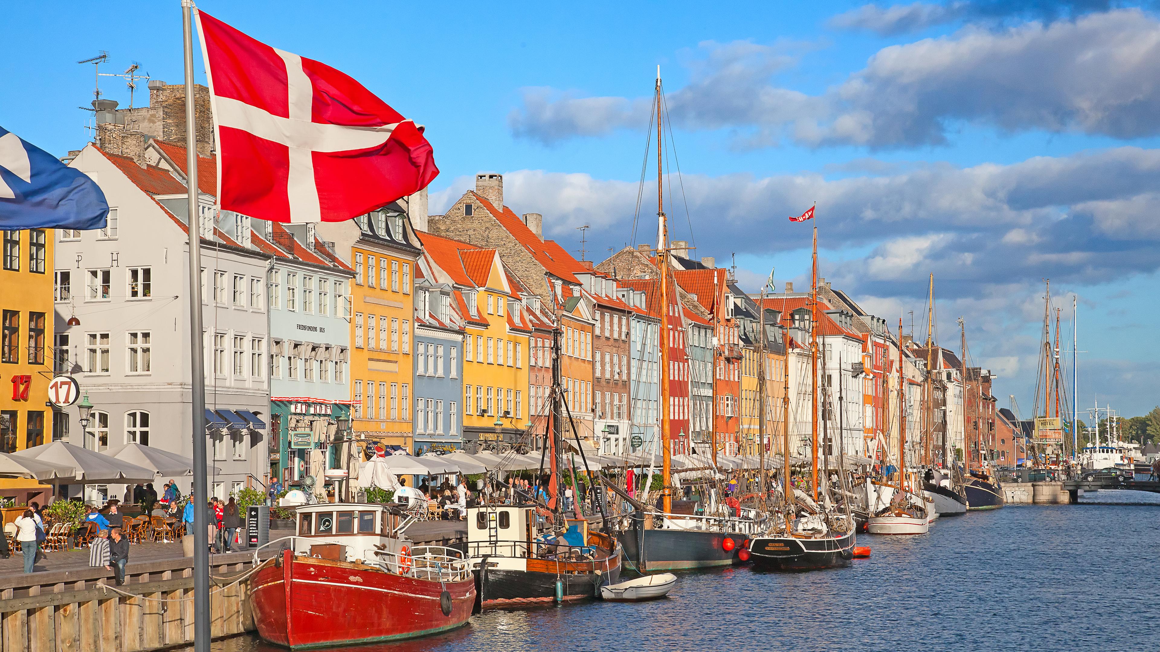 Nyhavn in Kopenhagen an einem sonnigen Tag es ist die dänische Flagge zu sehen. 