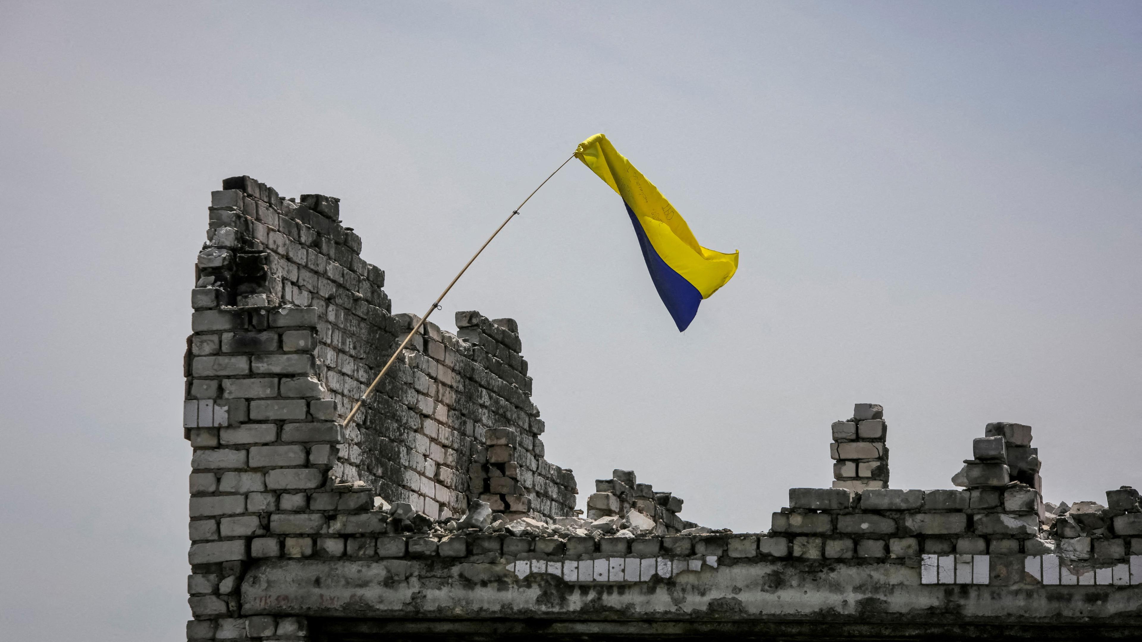 A Ukrainian national flag is seen near the front line in the newly liberated village Neskuchne