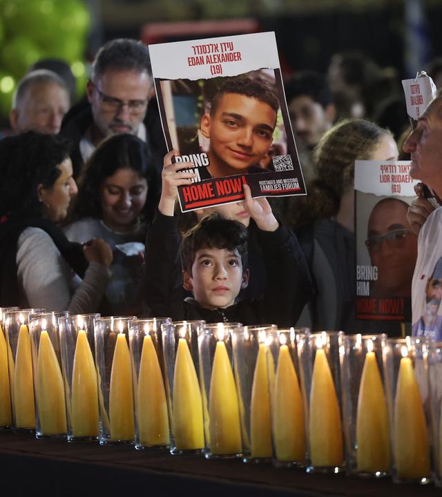 Menschen an einer Gedenkstätte zum Gedenken an die entführten Opfer