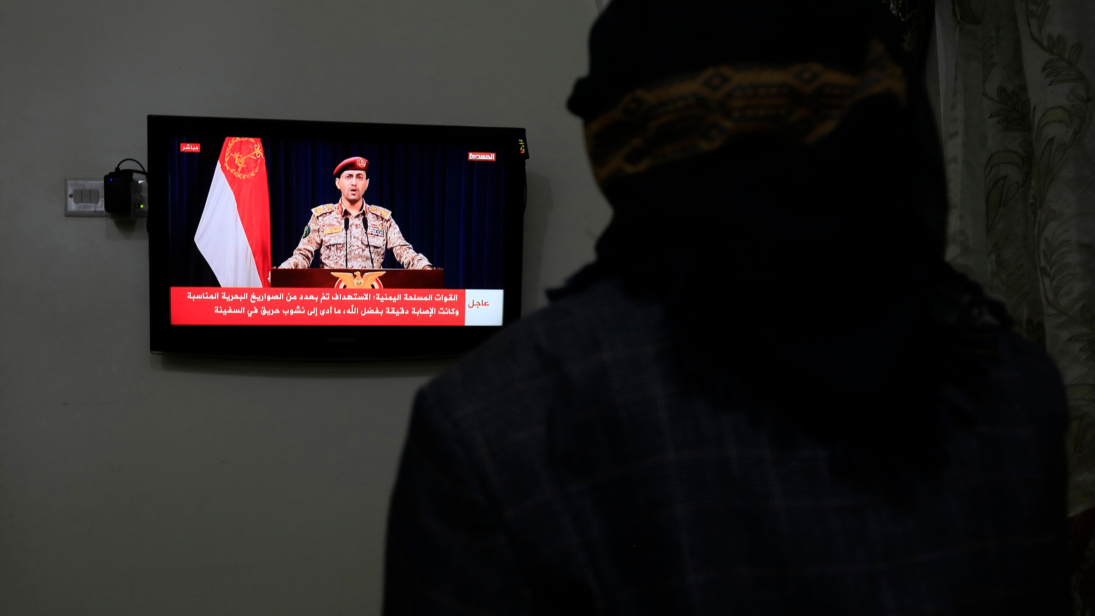 Sanaa, Jemen: Eine Person beobachtet einen Huthi-Militärsprecher bei einer Fernsehansprache über einen jüngsten Schiffsangriff im Golf von Aden.