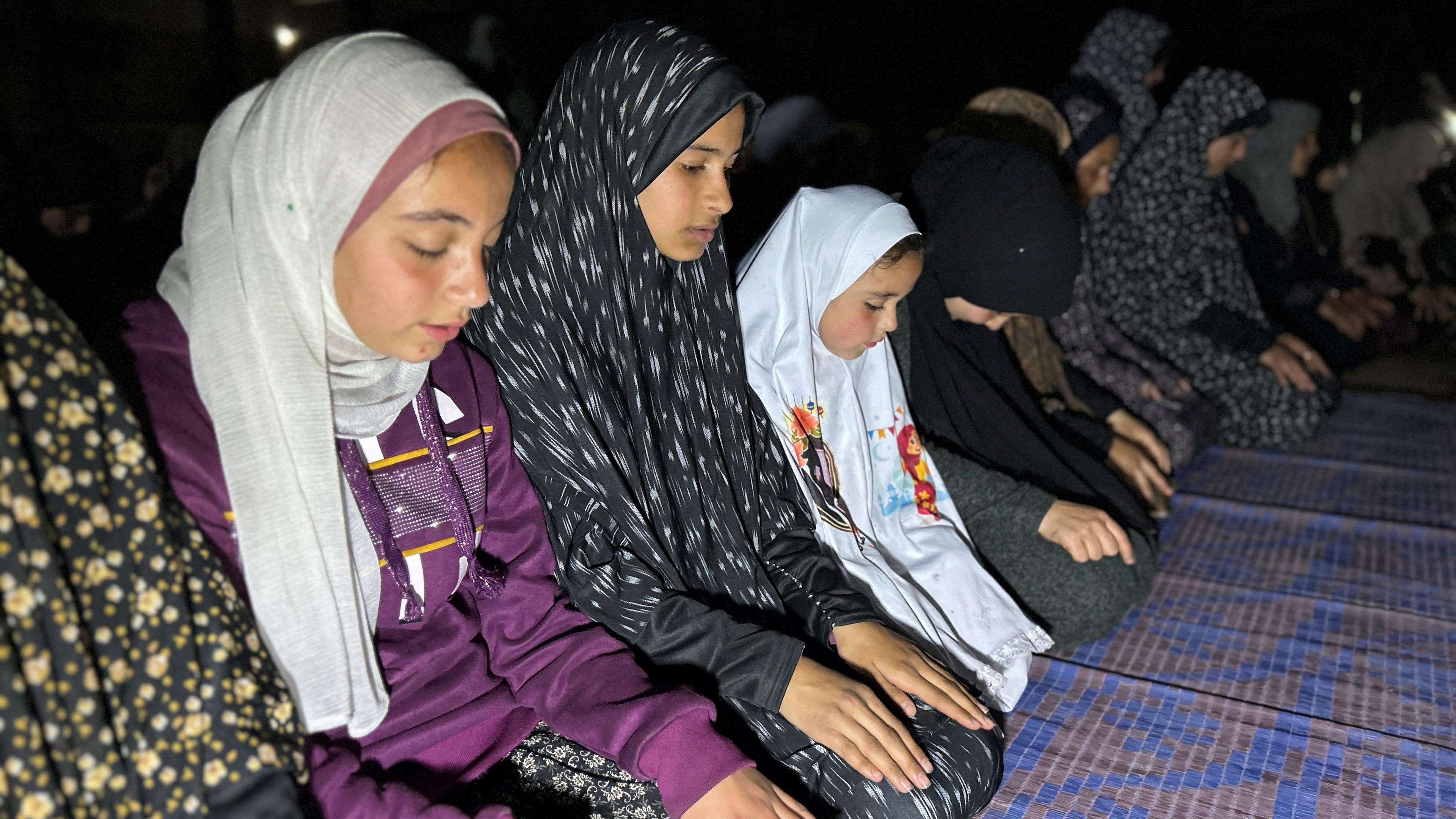 Palestinians perform Taraweeh prayers at a school during the holy month of Ramadan, as the conflict between Israel and Hamas con