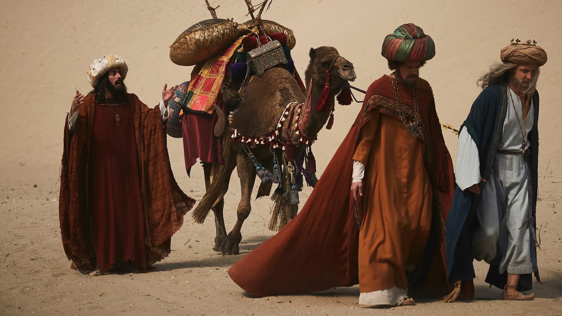 "Sketch History": In einer Wüstenlandschaft laufen drei Männer (vlnr.: Alexander Schubert, Max Giermann, Holger Stockhaus) mit Turban und bunten Gewändern hintereinander her. Der eine hält ein Kamel an der Leine, das bepackt ist mit kleinen Bronzekisten, bunten Tüchern und Trinksäcken.