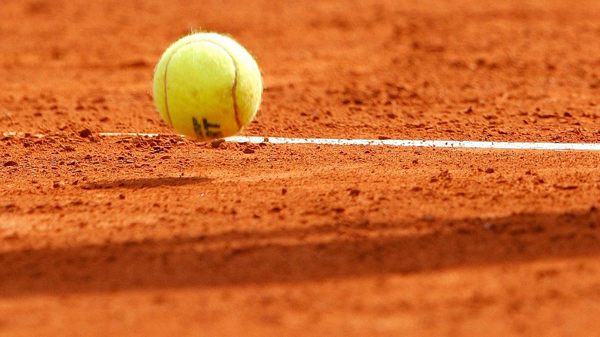 tennisball auf einem sandplatz - typical
