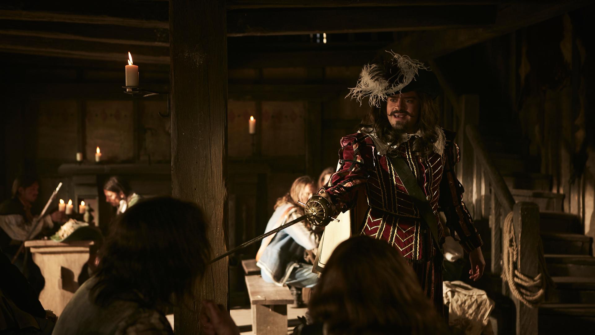 Der französische Austausch-Musketier (Max Giermann) stößt in Deutschland auf nur wenig Begeisterung. "Sketch History"-Spielszene in einem historischen Wirtshaus: Ein Mann mit Federhut und rot-goldenem Kostüm aus Samt streckt herausfordernd seinen Degen von sich.