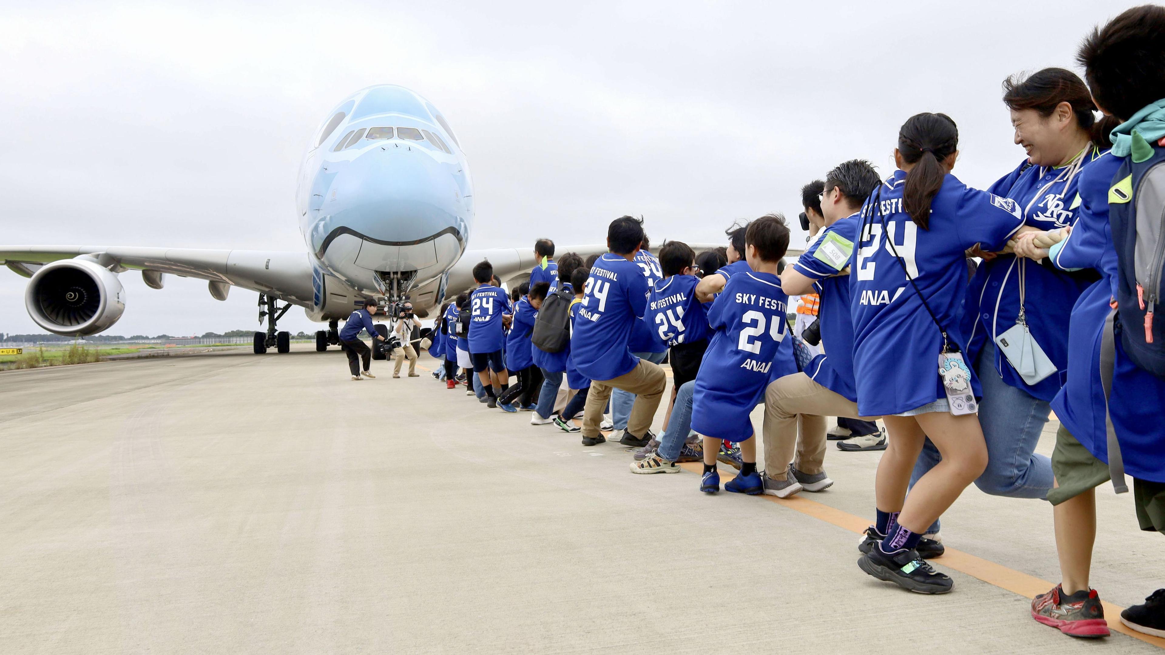 Rund 350 Grundschüler und ihre Betreuer ziehen auf dem Flughafen Narita in der Nähe von Tokio einen Airbus A380, das größte Passagierflugzeug der Welt mit einer Länge von etwa 73 Metern und einem Gewicht von rund 340 Tonnen.