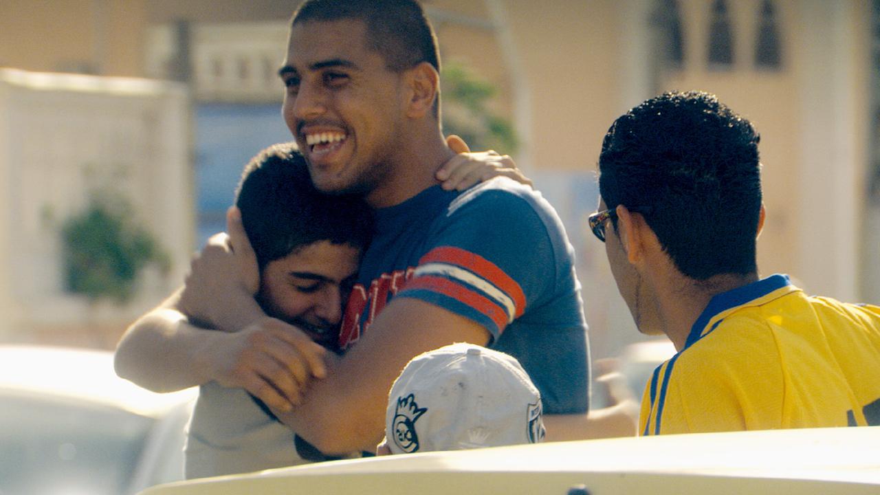 Szene aus "Ajami": Eine Gruppe von drei Männern. Zwei fallen sich um den Hals, einer ist von hinten zu sehen.