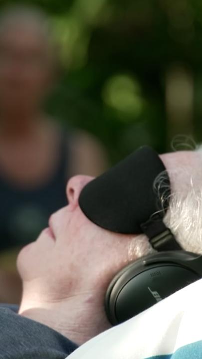 Frau hat Kopfhörer und Schlafmaske auf 