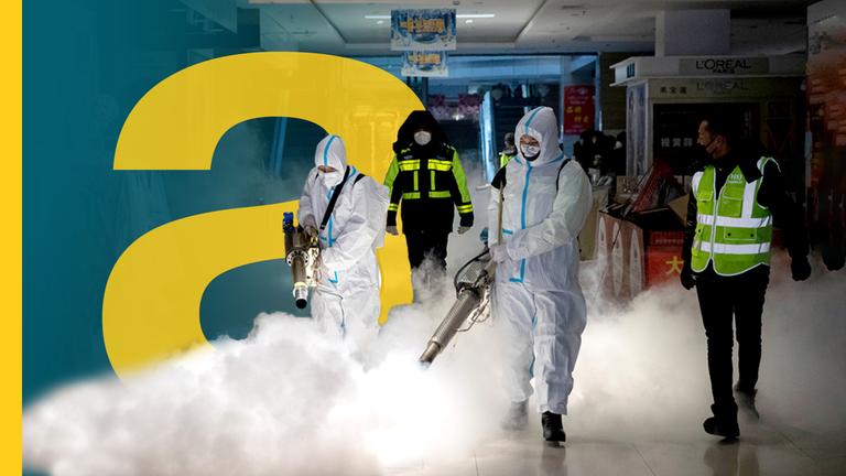 Menschen in Schutzanzügen desinfizieren eine Shopping Mall in China