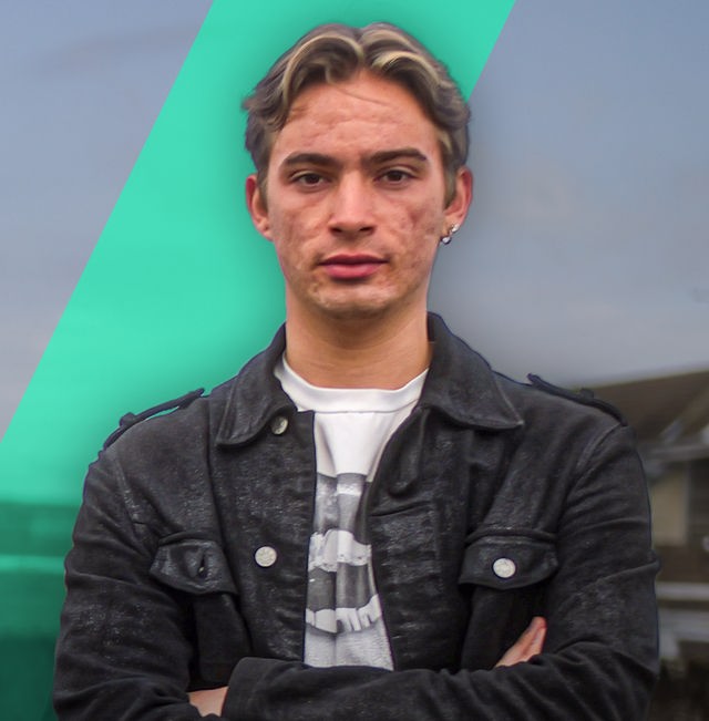 Auf rechten Bildseite schaut ein junger Mann nach vorne. Er trägt eine schwarze Jacke und hat seine Arme vor dem Oberkörpfer verschränkt. Auf der linken Bildseite ist ein älteres Foto des jungen Mannes zu sehen. Er hat auf dem Foto viel Akne im Gesicht.