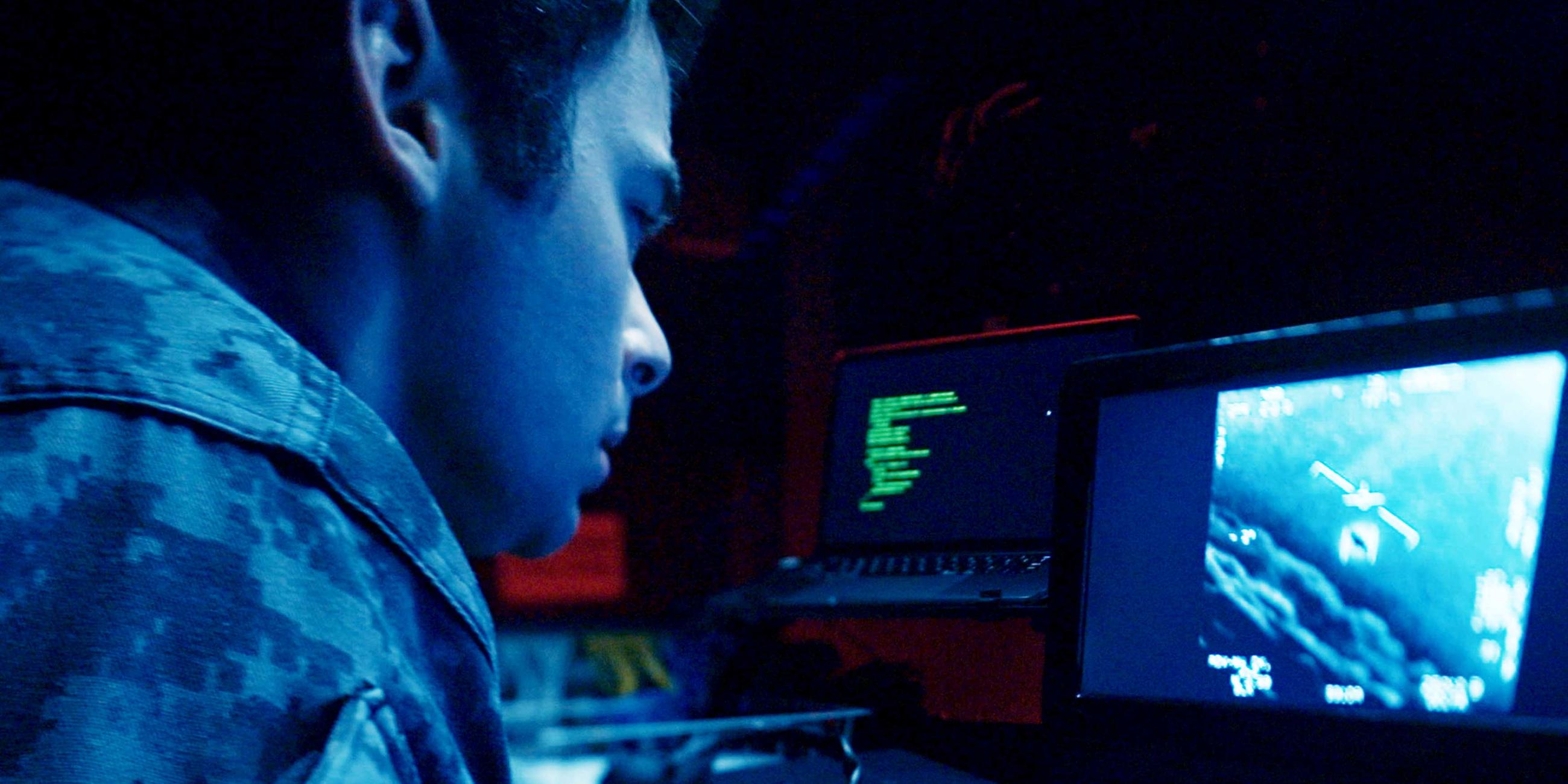  Ein Mann in Uniform schaut auf das Display eines Computers.