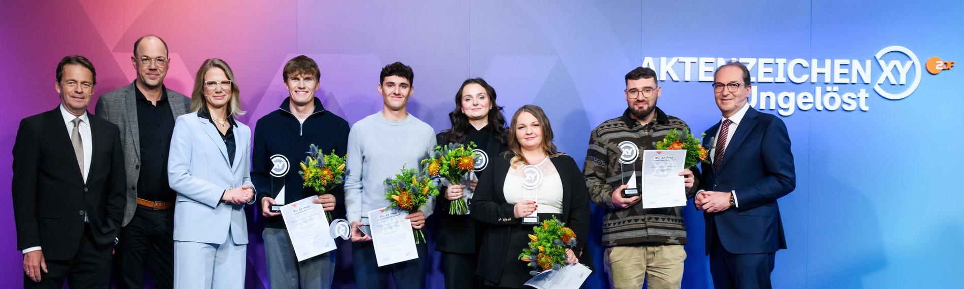 "Die Gewinner des XY-Preise 2025": von links Rudi Cerne,Frank Zervos, Nadine Bilke, Paul Georg, Elias Linz, Emma Tuscher, Inna Rommelfanger, Thomas Köpplin und Bundesinnenminister Alexander Dobrindt.
