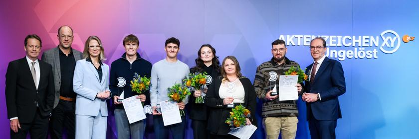 "Die Gewinner des XY-Preise 2025": von links Rudi Cerne,Frank Zervos, Nadine Bilke, Paul Georg, Elias Linz, Emma Tuscher, Inna Rommelfanger, Thomas Köpplin und Bundesinnenminister Alexander Dobrindt.