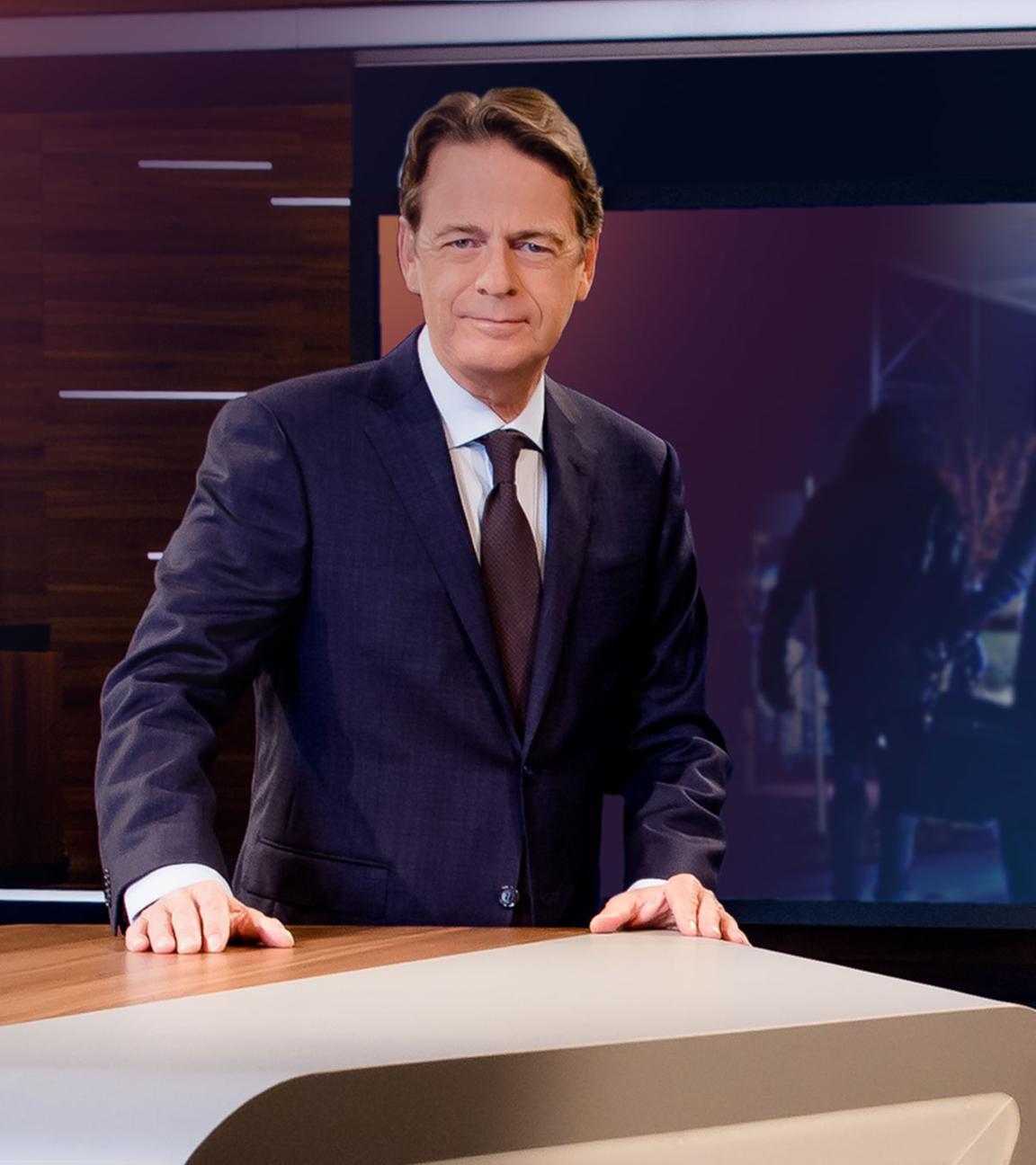 "Aktenzeichen XY... Ungelöst vom 17. April 2024": Moderator Rudi Cerne steht im Studio, im Hintergrund ein Bildschirm, auf dem ein Fall der Sendung abgebildet ist.  