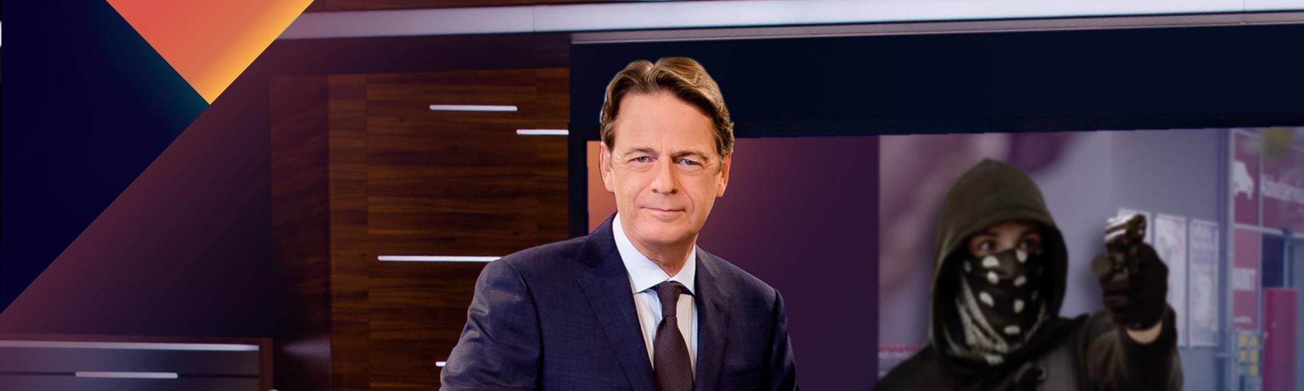 "Aktenzeichen XY... Ungelöst vom 8. Mai 2024": Moderator Rudi Cerne steht im Studio, im Hintergrund ein Bildschirm, auf dem ein Fall der Sendung abgebildet ist.  