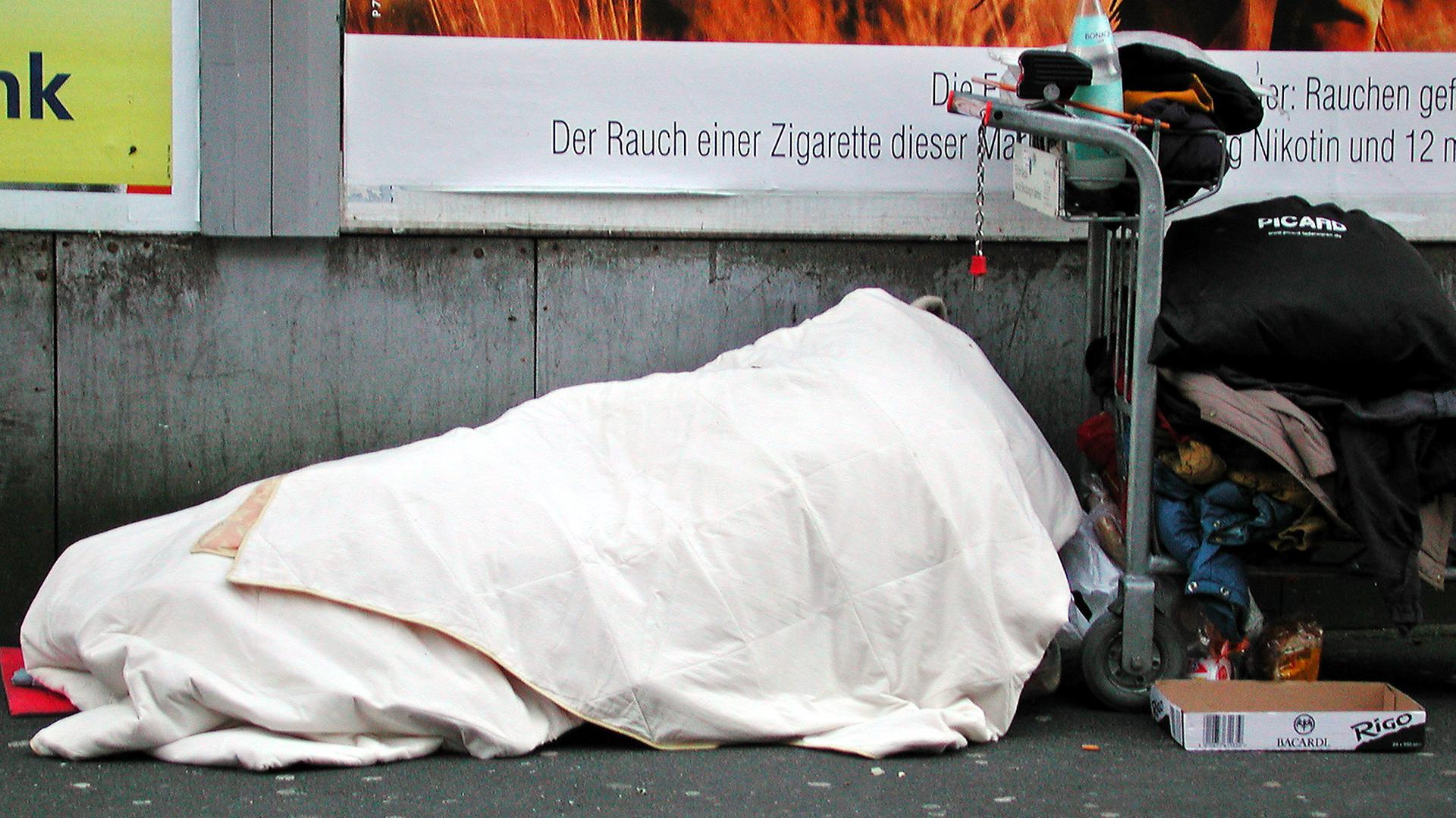 Obdachloser liegt auf Straße