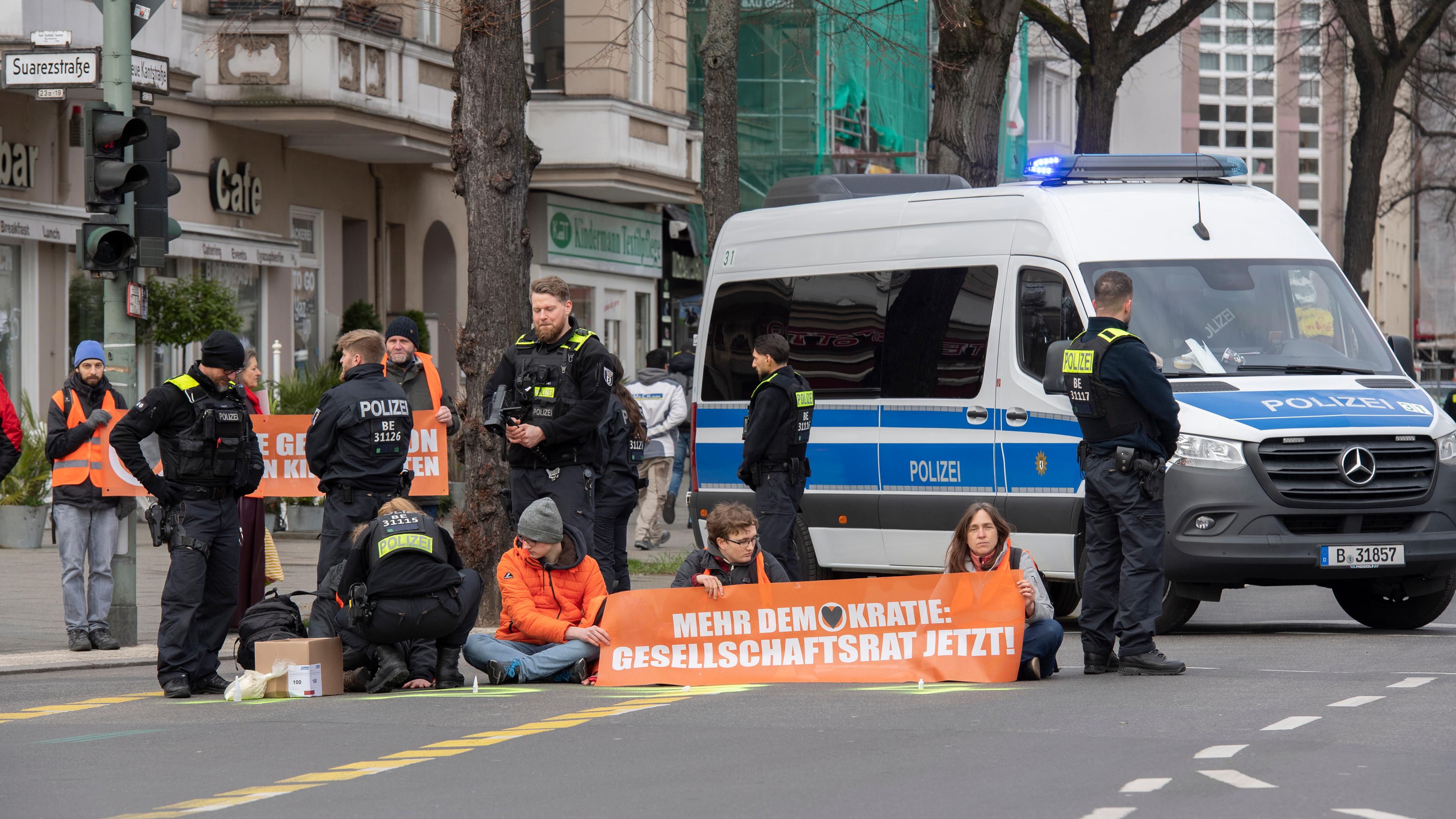 Berlin: Aktivisten der Gruppe "Letzte Generation" haben sich auf der Neuen Kantstraße auf einer Kreuzung festgeklebt. Archivbild