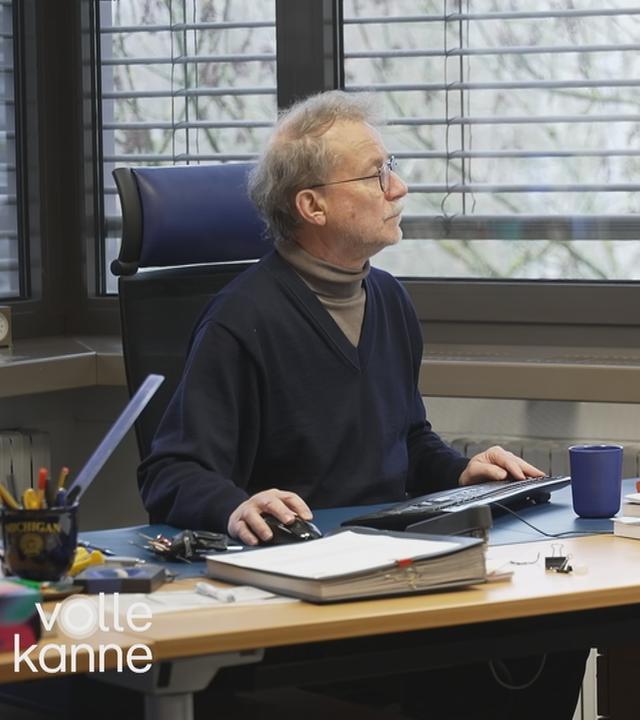 Alter Mann sitzt am Rechner im Büro