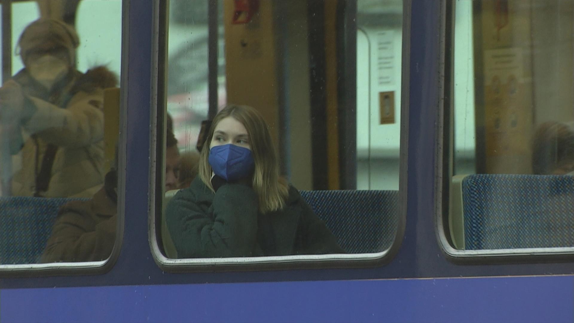 Auf dem Bild ist eine Frau mit Maske in der S-Bahn zu sehen.