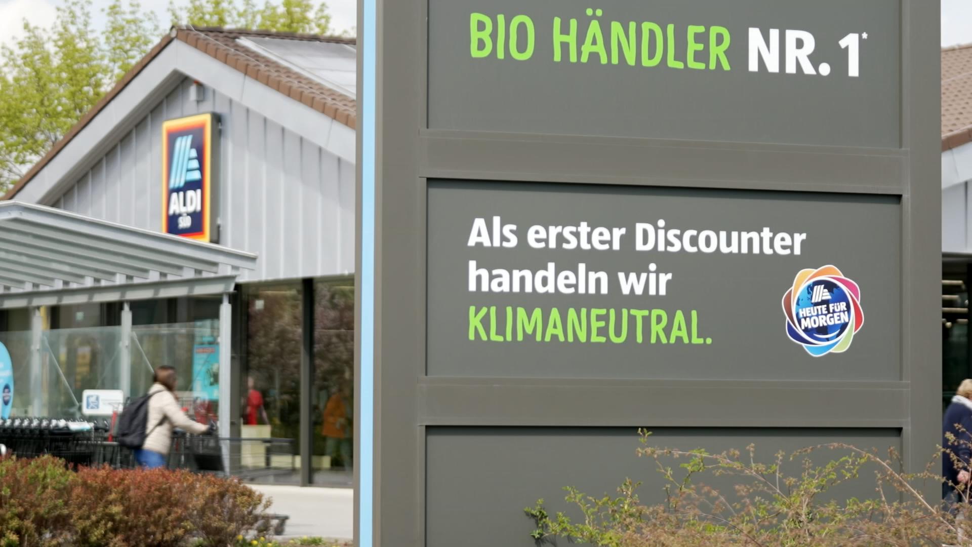Schild vor ALDI Süd: "Als erster Discounter handeln wir klimaneutral"