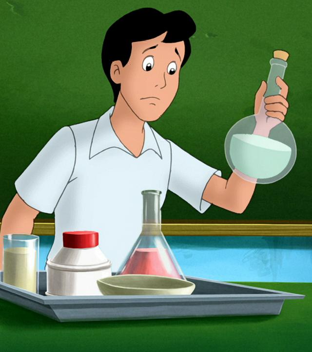 Alexander steht vor der Schultafel am Chemie-Versuchstisch und schaut etwas hilflos auf eine Laborflasche. 