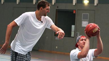 Alexander, mit dem Basketball in der Hand, trainert mit Dirk Nowitzki.