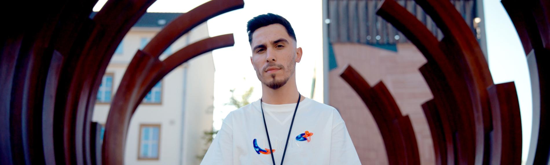 Ali471 steht in einer Metallkonstruktion, die wie ein riesiges Gerippe aussieht.