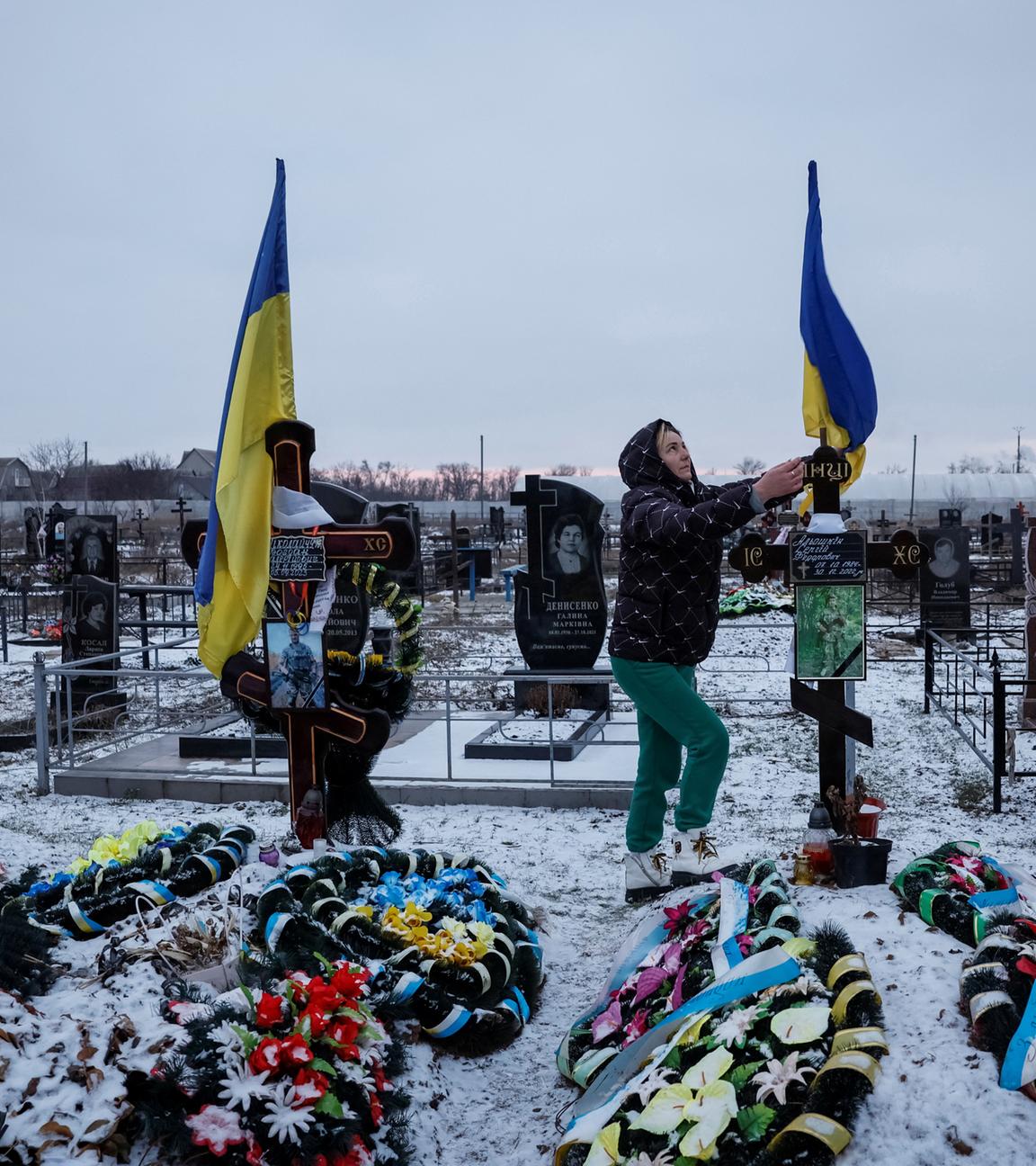 Alona Onyshchuk, 39, besucht das Grab ihres Mannes in der Allee der Helden auf einem örtlichen Friedhof inmitten des russischen Angriffs auf die Ukraine im Dorf Lozuvatka, Region Dnipropetrovsk, 22.01.2024.
